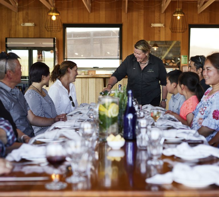 A group of tourists sitting at a table awaiting a meal